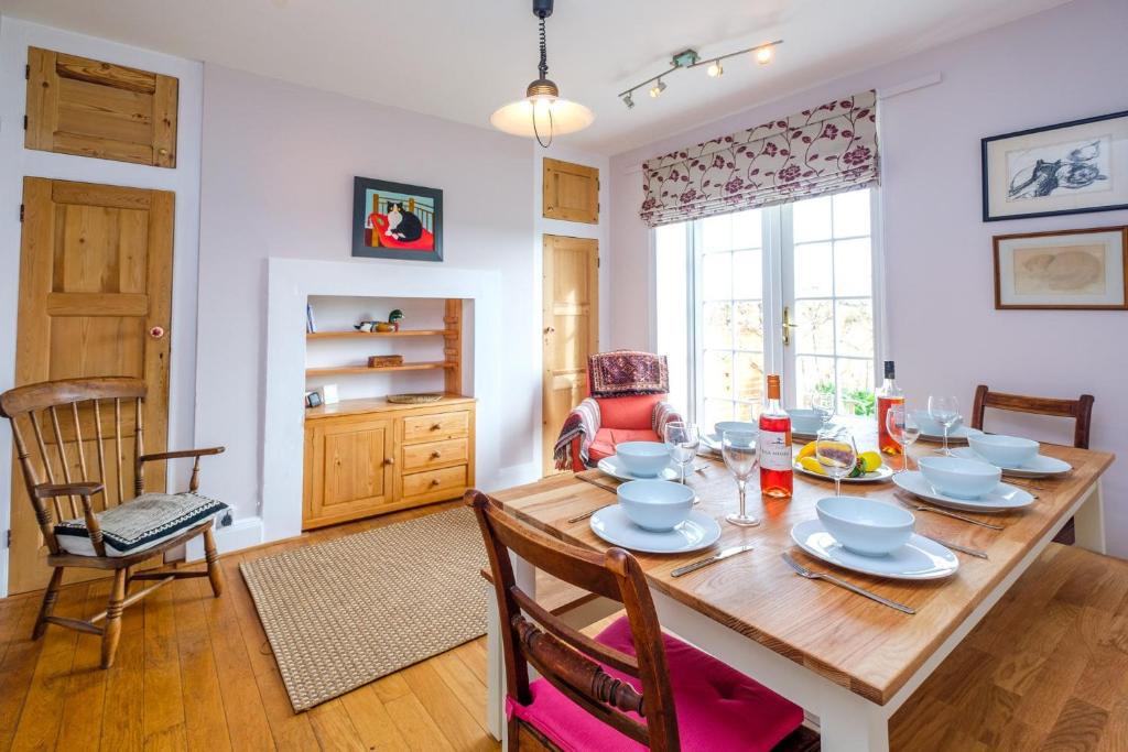 a dining room with a wooden table and chairs at Beach House - Aldeburgh Coastal Cottages in Aldeburgh