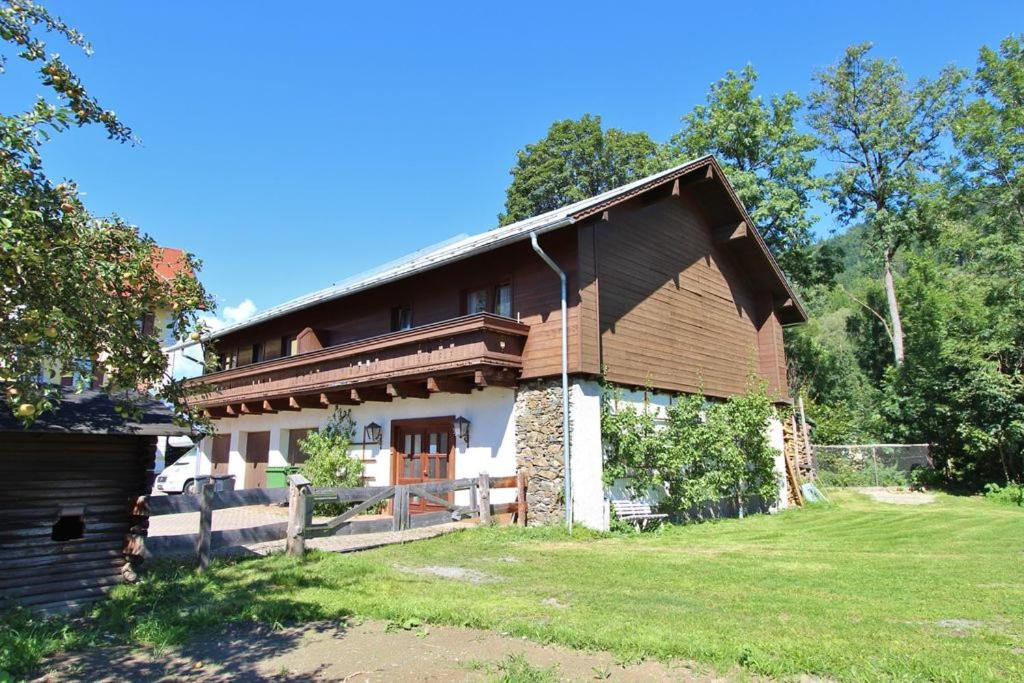 a large wooden house with a green yard at Ferienhaus Pichl in Bruck an der Großglocknerstraße