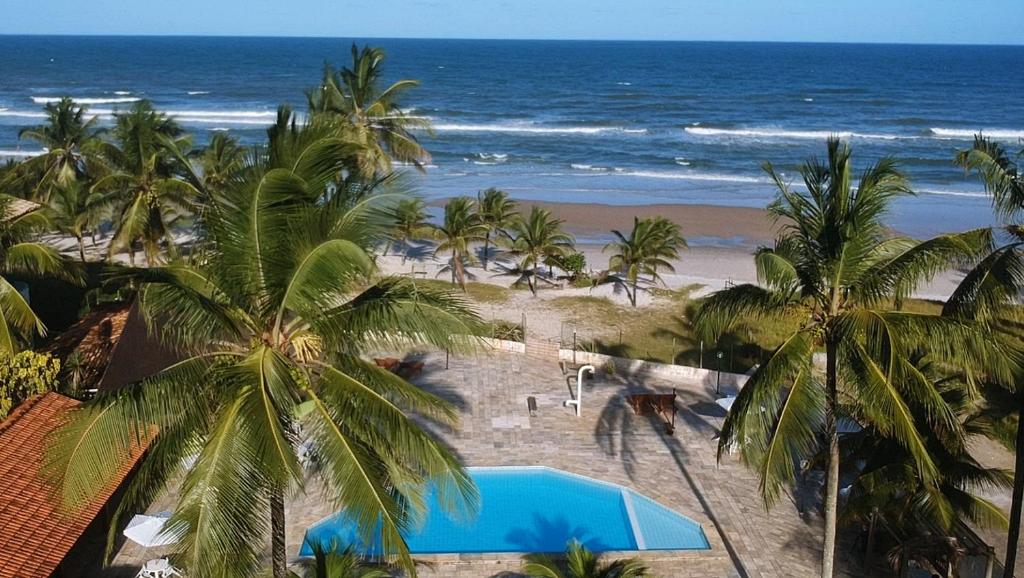 Blick auf einen Strand mit Palmen und das Meer in der Unterkunft Hotel La Dolce Vita in Ilhéus