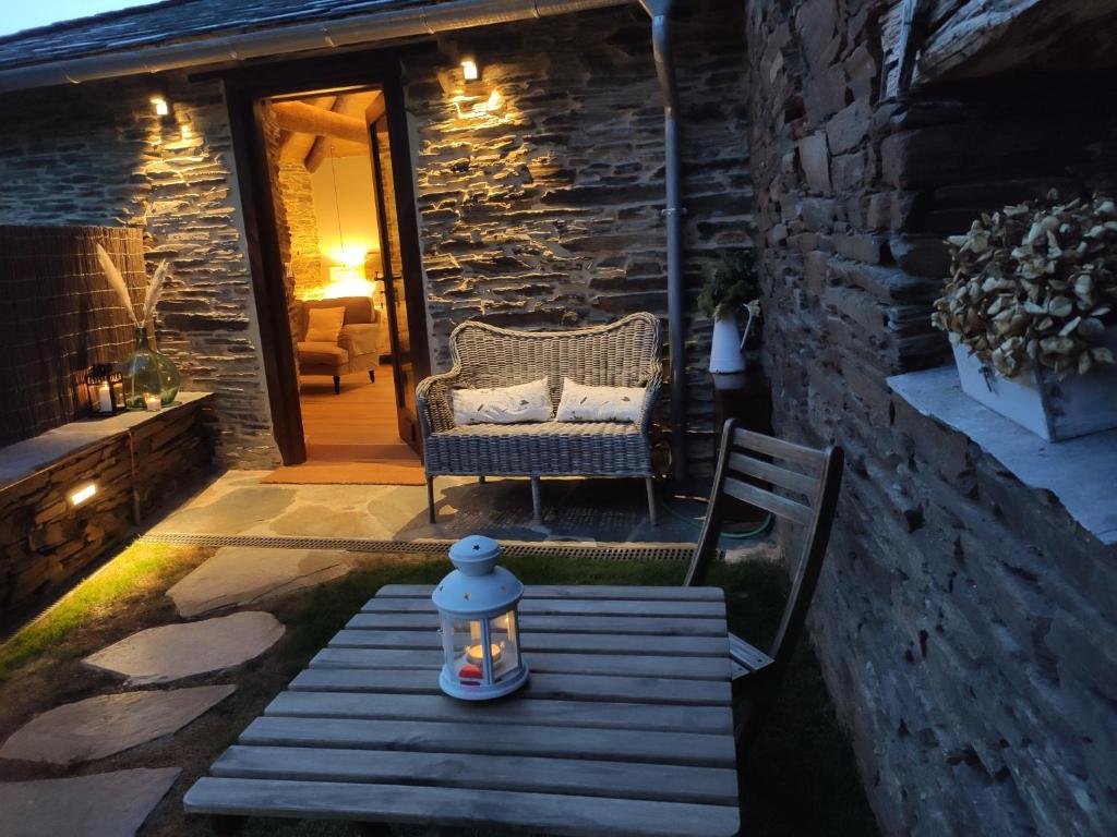 a patio with a bench and a table with a lantern at Casas de Outeiro in Samos