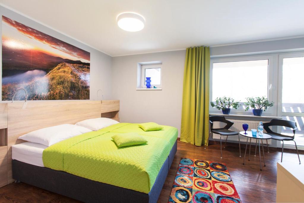 イェレニャ・グラにあるIdar Apartamentyのベッドルーム1室(大型ベッド1台、テーブル、椅子付)