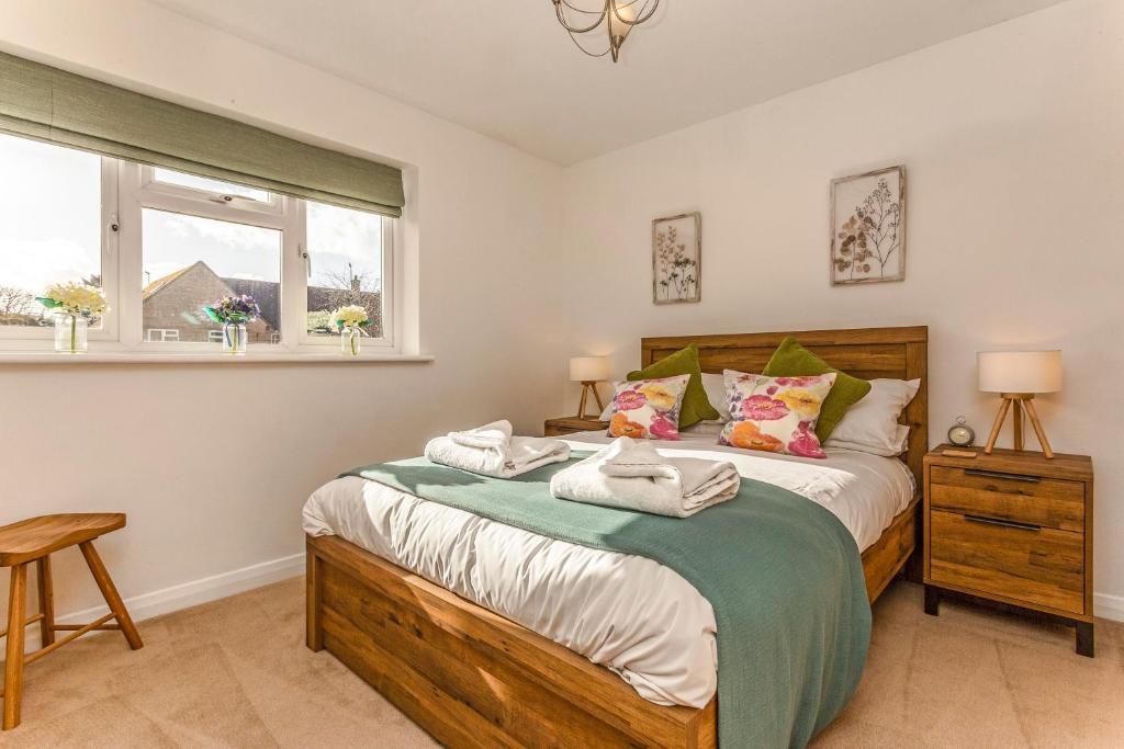 um quarto com uma cama e uma janela em Ardenlea em Bourton on the Water