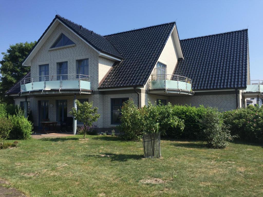 uma casa com um telhado preto e um quintal em Haus Carmen auf Usedom Nr.6 em Ziemitz