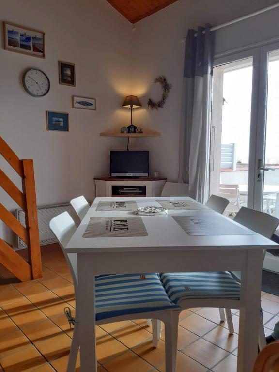 - une table et des chaises blanches dans le salon dans l&#39;établissement Superbe vue sur l&#39;océan, accès direct à la plage, à La Tranche-sur-Mer