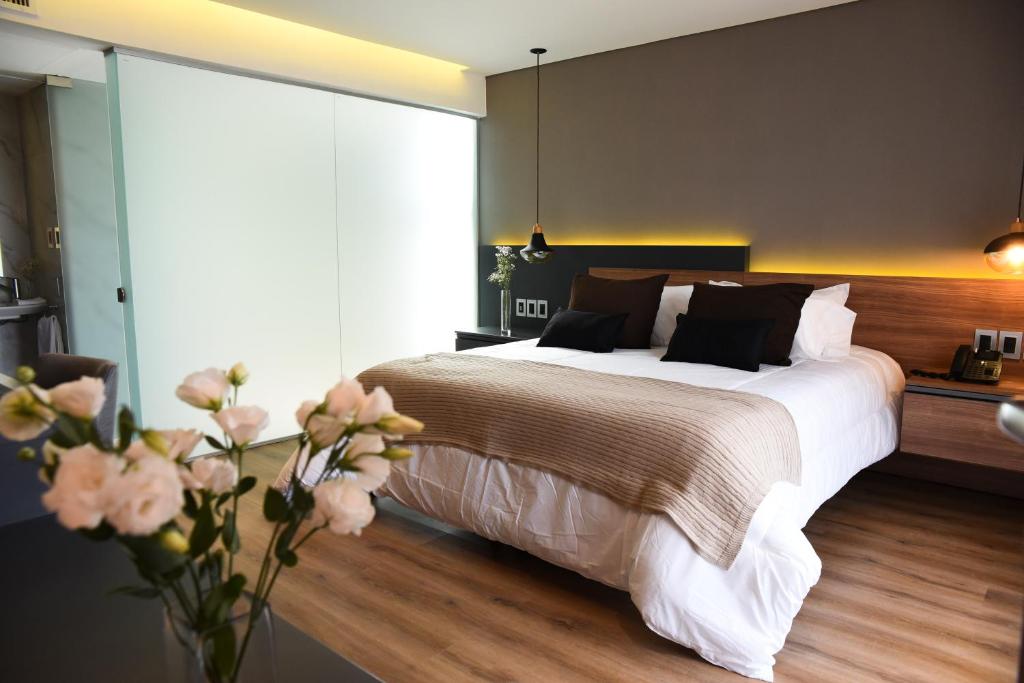 um quarto com uma cama grande e um vaso de flores em Hotel Soho Suites em San Francisco
