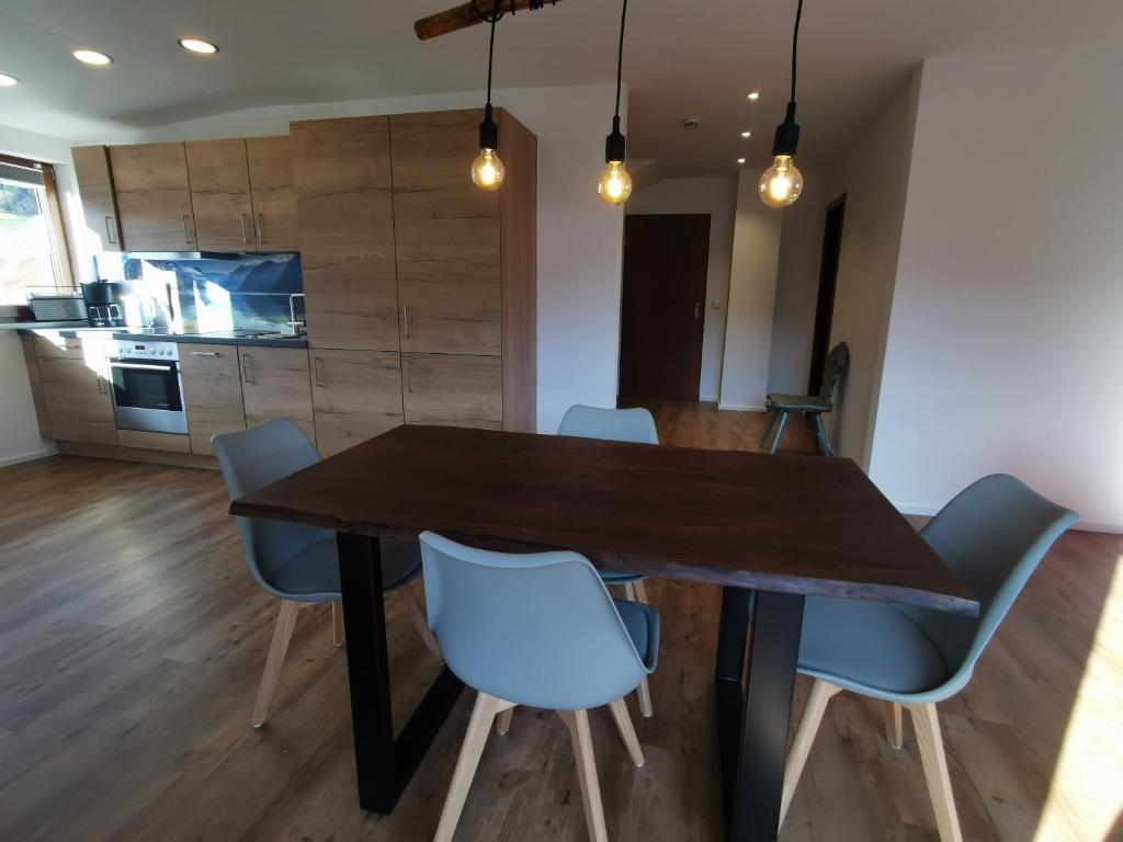 a dining room with a wooden table and blue chairs at Ferienwohnung Stillleben in Ofterschwang