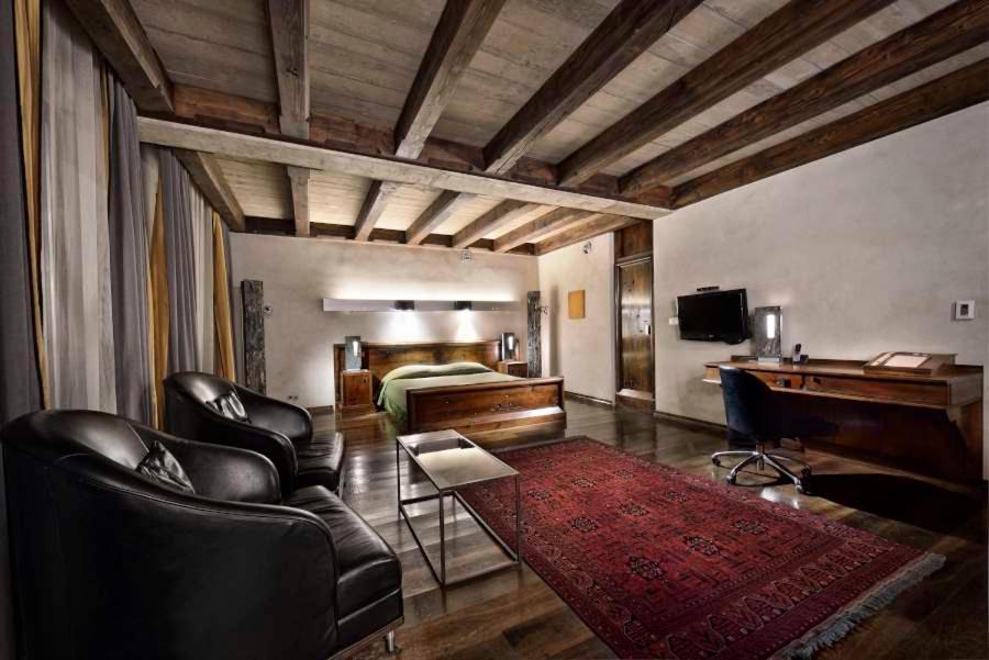 a bedroom with a bed and a desk and chairs at Hotel Stary in Kraków