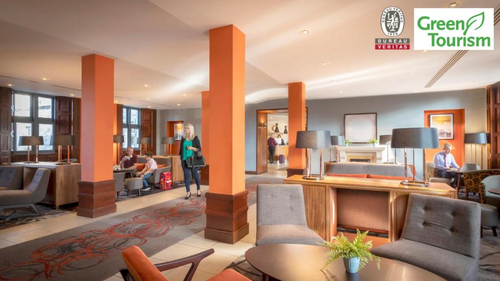 a lobby of a hotel with people sitting in chairs at Clayton Hotel & Leisure Club Sligo in Sligo