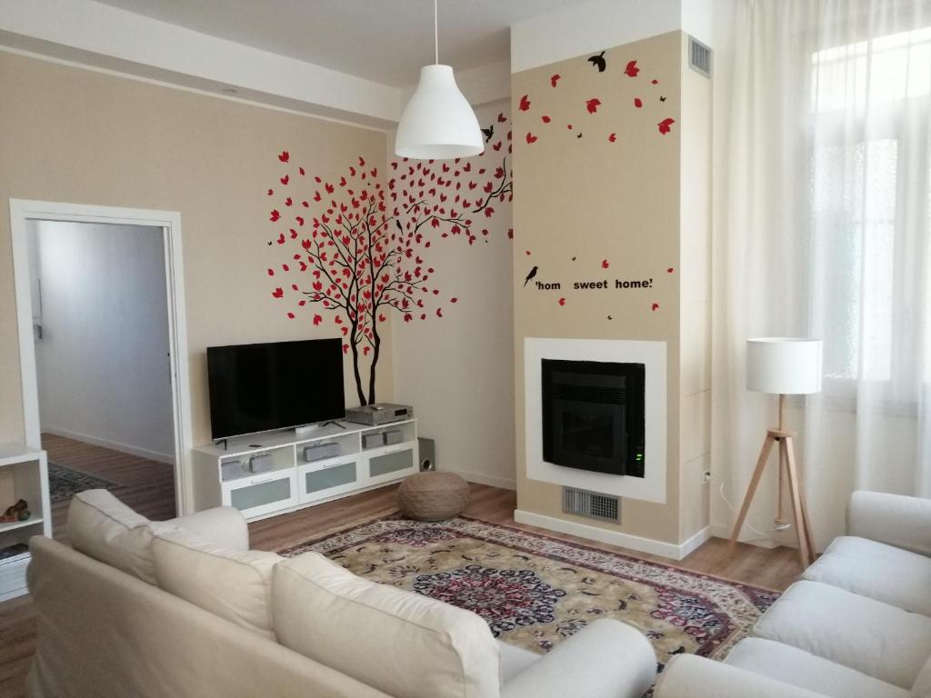 a living room with a white couch and a tree at Ginny's Room in Quartu SantʼElena