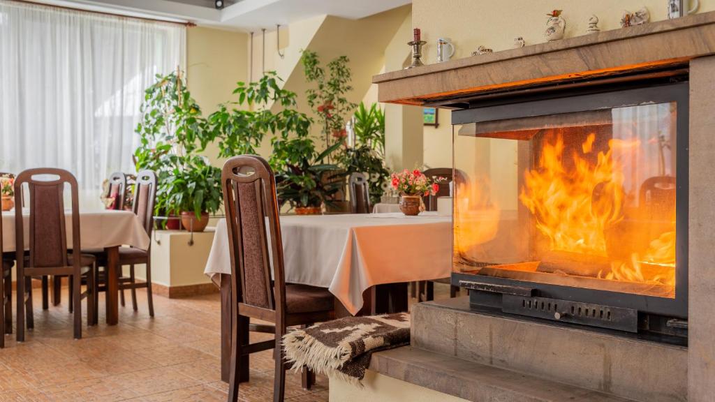 a fireplace in a restaurant with a table and a dining room at Pensiunea Ana in Cavnic