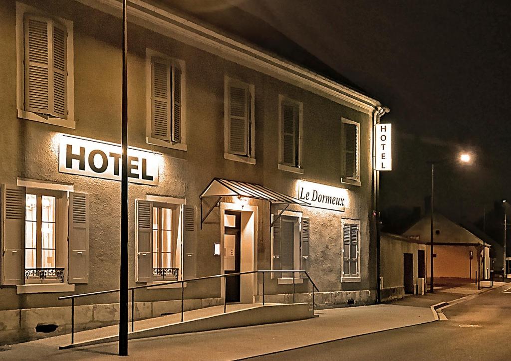 a hotel with lights on the side of a building at Hôtel Le Dormeux in Mehun-sur-Yèvre