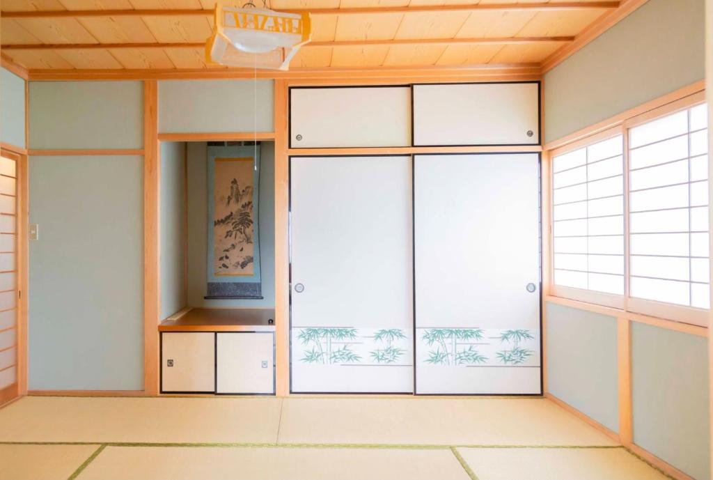 um quarto vazio com portas de correr e janelas em Machiyado AETE - Vacation STAY 22032v em Sanuki