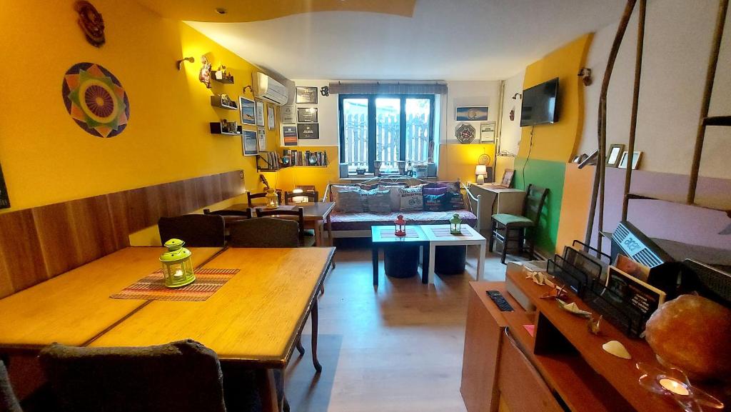 a living room with yellow walls and a wooden table at Shanti Hostel in Skopje