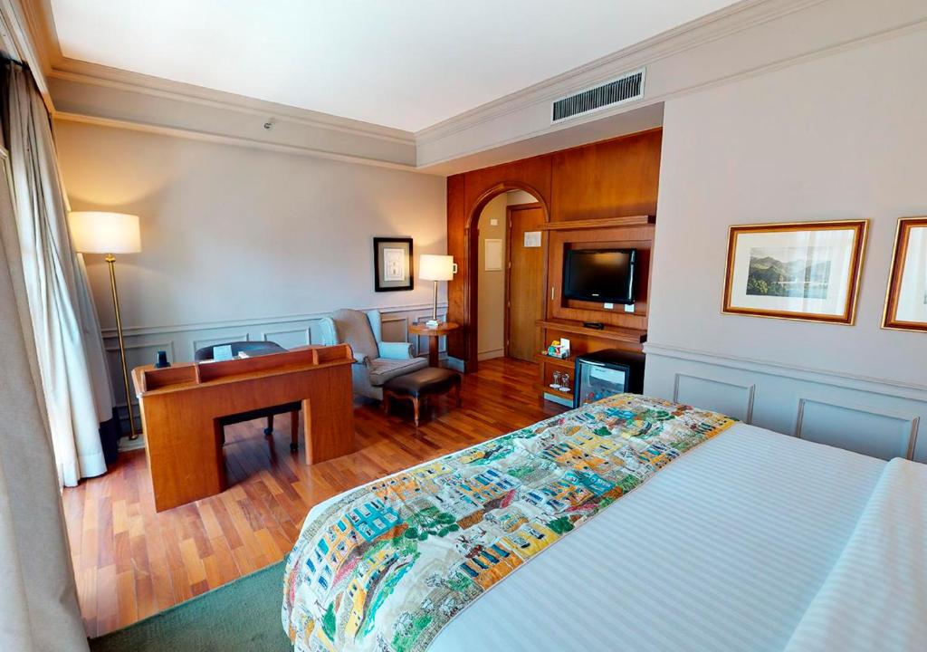 ein Schlafzimmer mit einem Bett und einem Schreibtisch sowie ein Zimmer in der Unterkunft Gran Estanplaza Berrini in São Paulo