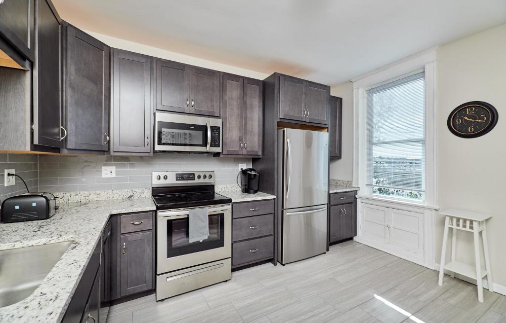 a kitchen with wooden cabinets and stainless steel appliances at Forest park, Science Center, BJC & CWE restaurants in Tower Grove