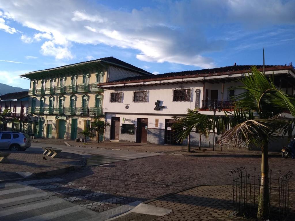 SonsónにあるHotel Tahamiの通りの前にヤシの木がある建物