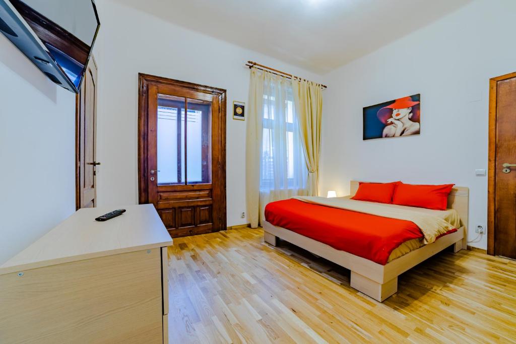 a bedroom with a bed with red pillows on it at Old City Lux 2 in Braşov