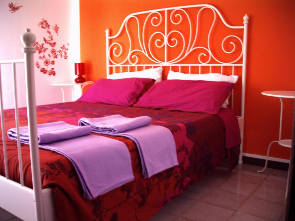 een slaapkamer met een bed met roze en paarse lakens bij Su Planu in Cagliari