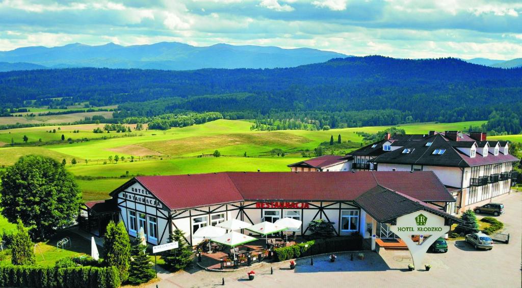 - une vue aérienne sur un complexe avec des montagnes en arrière-plan dans l'établissement Hotel Kłodzko, à Kłodzko