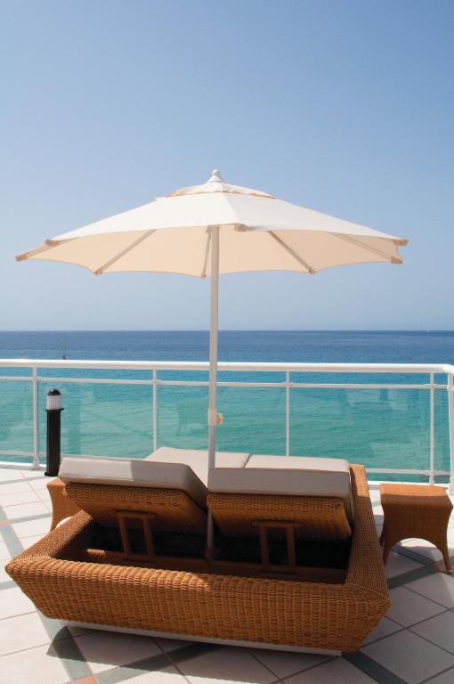 a white umbrella sitting on top of a deck at XQ El Palacete in Morro del Jable