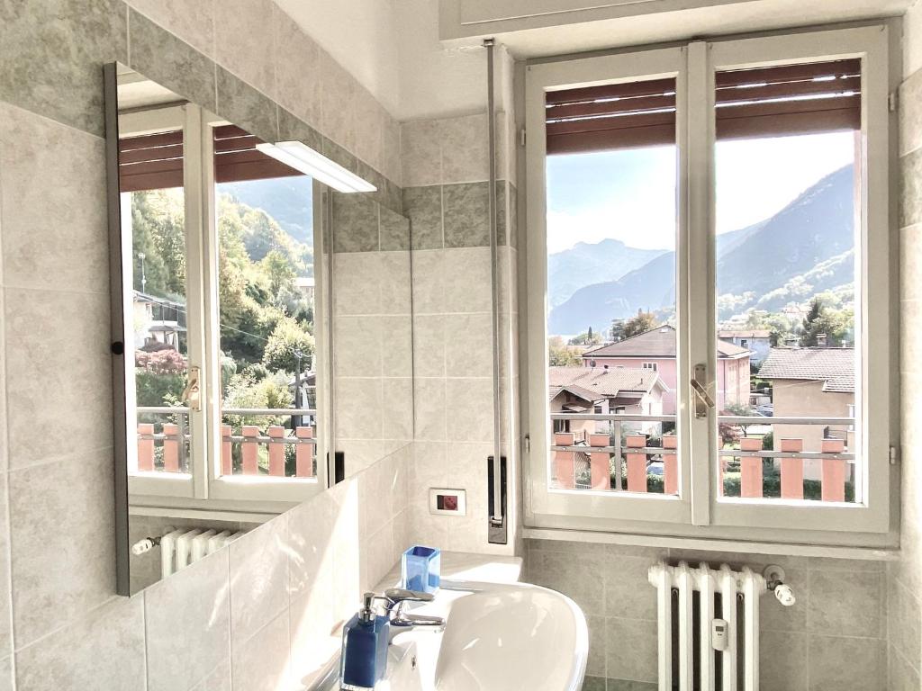 a bathroom with a sink and a mirror and a window at Victoria Apartment in Oliveto Lario