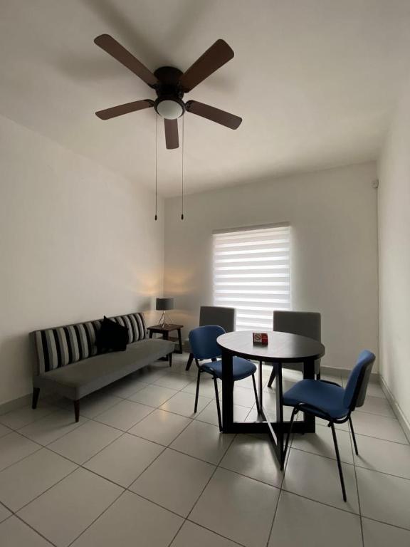 a living room with a ceiling fan and a table and chairs at DEPARTAMENTOS GARI in Córdoba