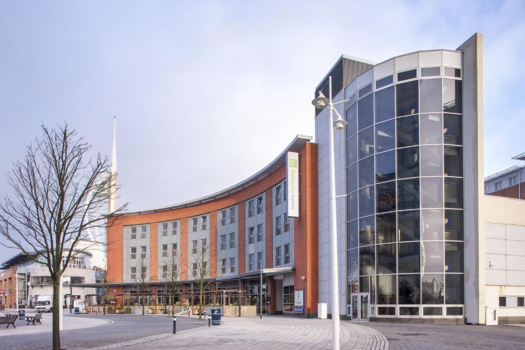 un gran edificio de cristal en una ciudad en Holiday Inn Express Portsmouth Gunwharf Quays, an IHG Hotel, en Portsmouth