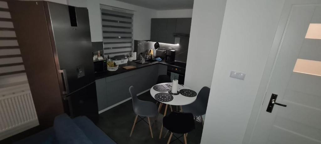 - une petite cuisine avec une petite table et des chaises dans l'établissement Apartment Manhattan, à Tarnowskie Góry