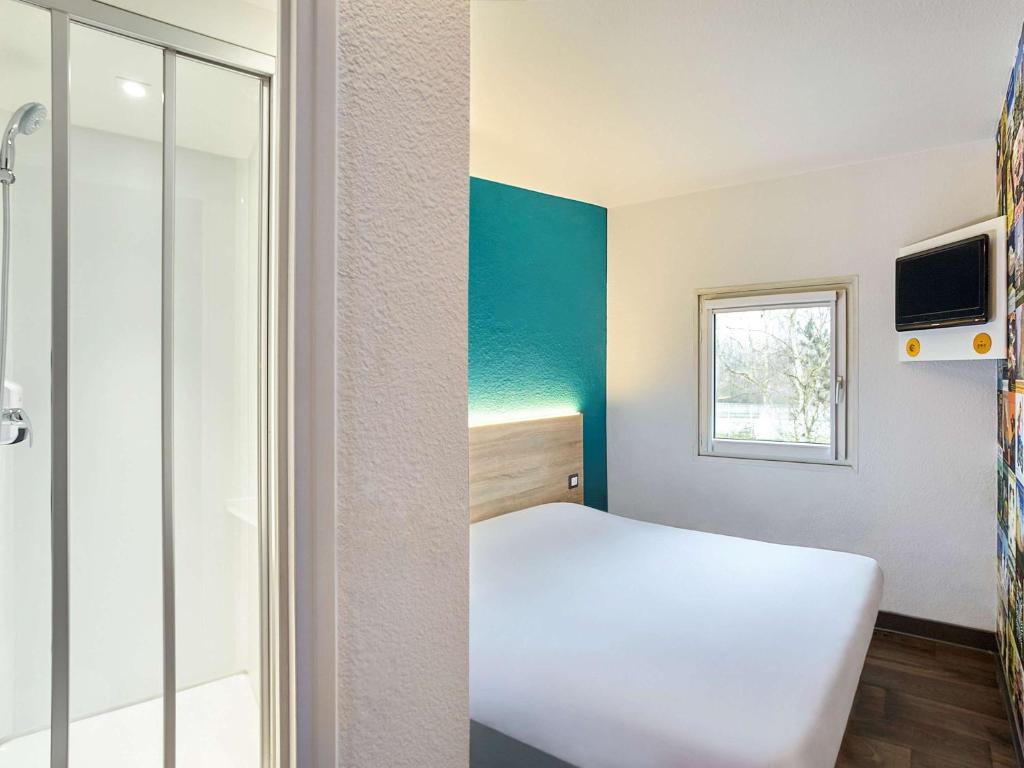 ベジエにあるhotelF1 Béziers Estのベッドと窓が備わる小さな客室です。