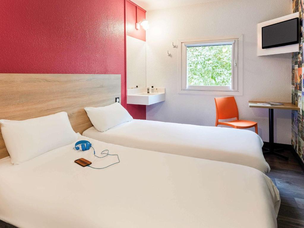 a hotel room with two beds and a sink at hotelF1 Saint Etienne in Saint-Étienne