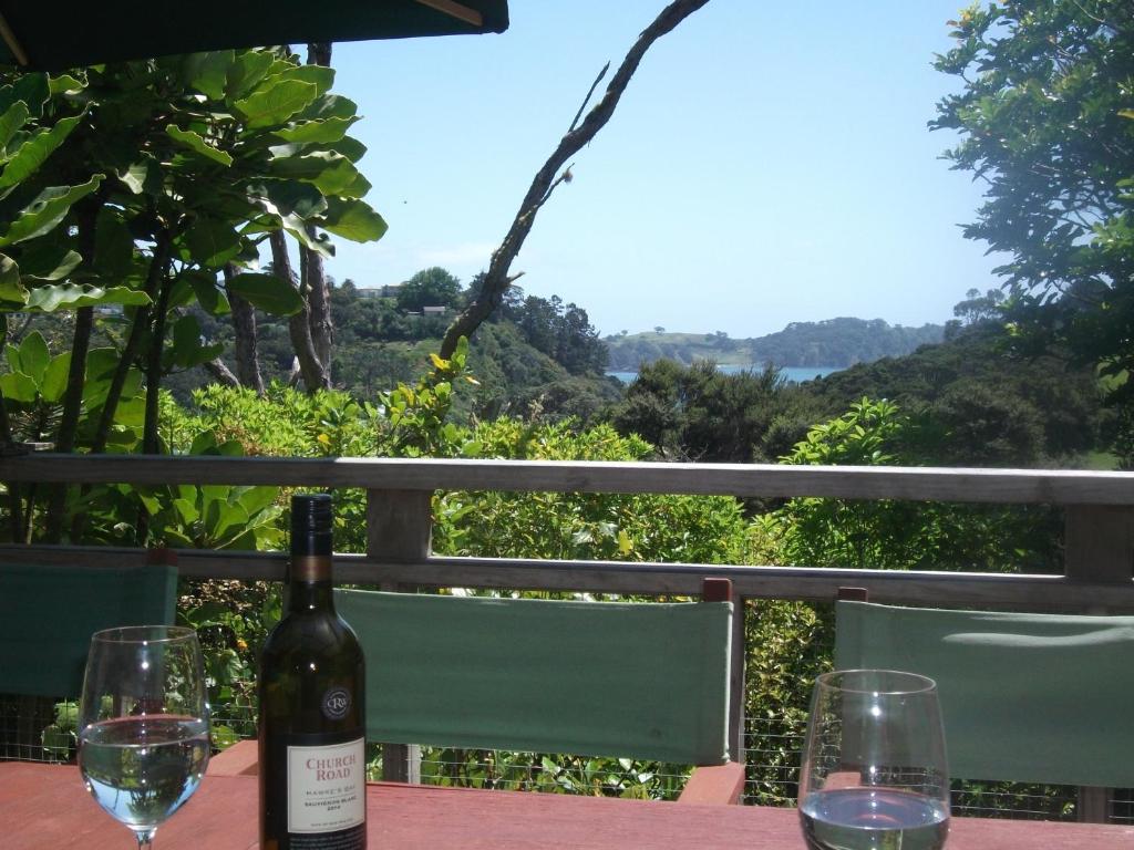 een fles wijn zittend op een tafel met twee glazen bij Bush Beach Delight - Onetangi Holiday Home in Onetangi