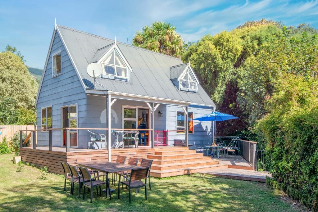 a tiny house with a table and chairs on a deck at HH Akaroa - Akaroa Holiday Home in Akaroa