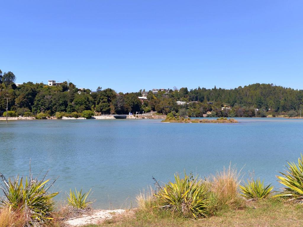 凱特里特里的住宿－Blue Lagoon - Kaiteriteri Holiday Unit，一大片水,有树在背后