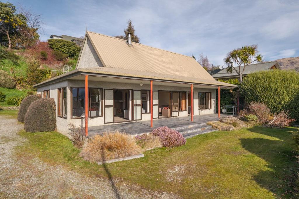 a house with a porch and a yard at Sycamore Place - Wanaka Holiday Home in Wanaka