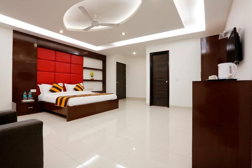 um quarto com uma cama e uma cabeceira vermelha em Hotel Anand Lok Inn em Nova Deli