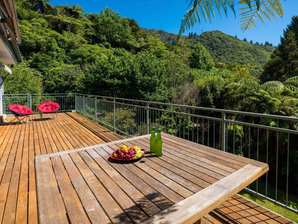 a wooden deck with a bowl of fruit on it at Serene Sounds - Anakiwa Holiday Home in Anakiwa