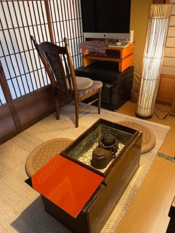 ein Wohnzimmer mit einem Tisch und einem Stuhl in der Unterkunft 古民家ゲストハウス穏 in Sakaide