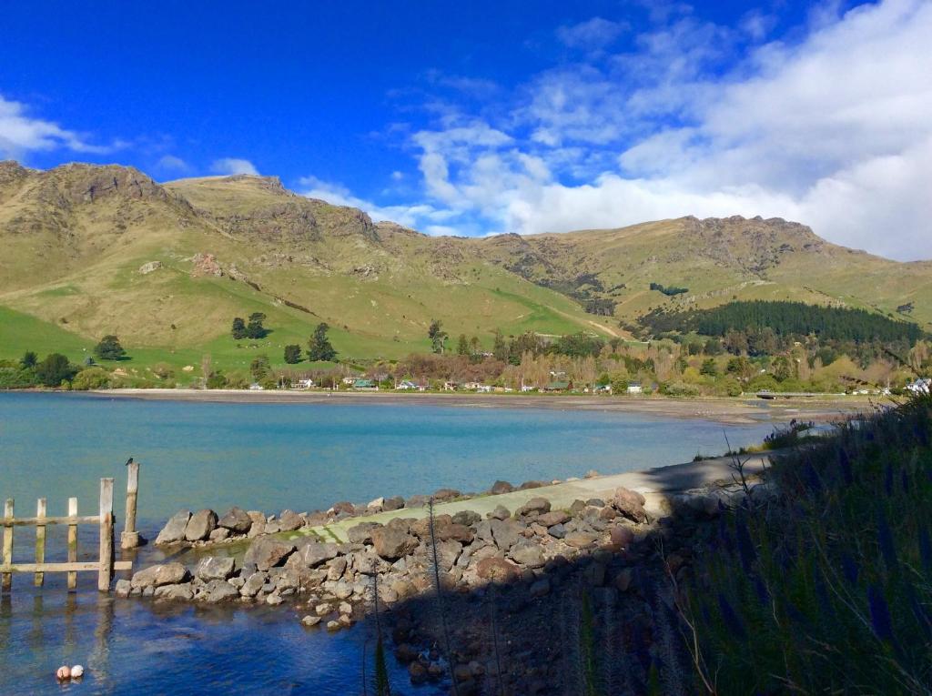 a body of water with mountains in the background at Shiloh - Diamond Harbour Accommodation in  Lyttelton