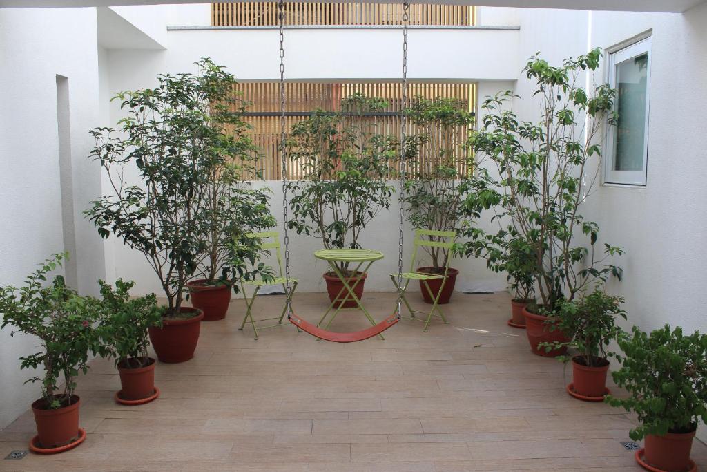 a room with potted trees and a table and chairs at Sunnyside Hotel in Kaohsiung