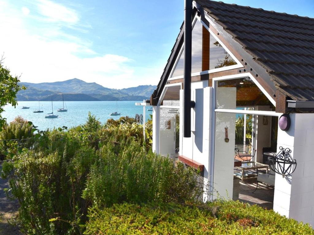 a white house with a view of the water at Anchor in Akaroa - Akaroa Holiday Home in Akaroa