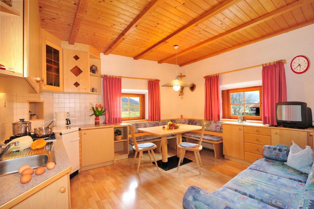 eine Küche und ein Wohnzimmer mit einem Tisch und einem Sofa in der Unterkunft Unterfinser in Lajen