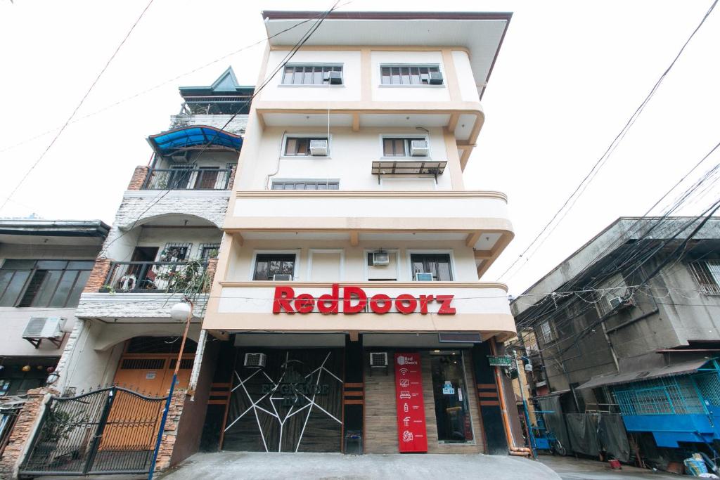 un bâtiment avec un panneau rouge devant lui dans l'établissement RedDoorz @ PIY Margal Sampaloc Manila, à Manille