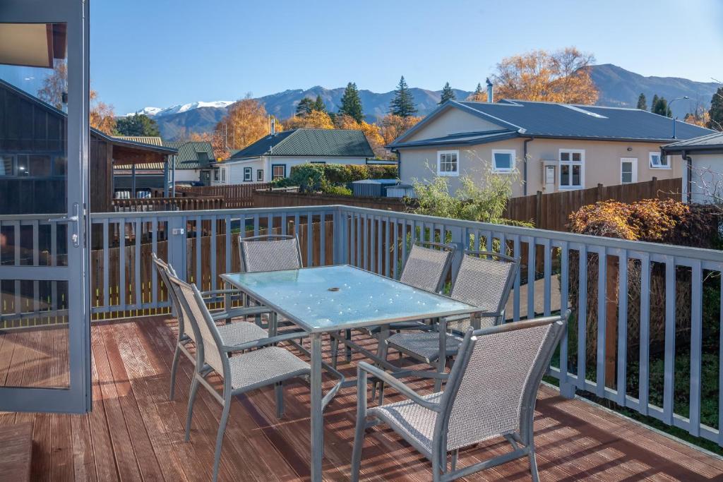 a patio with a table and chairs on a deck at Hanmer's Rose - Hanmer Springs Holiday Home in Hanmer Springs