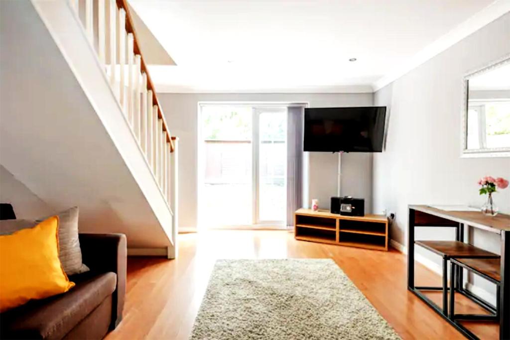 ein Wohnzimmer mit einem Sofa und einem TV in der Unterkunft Eagle Drive in Hendon