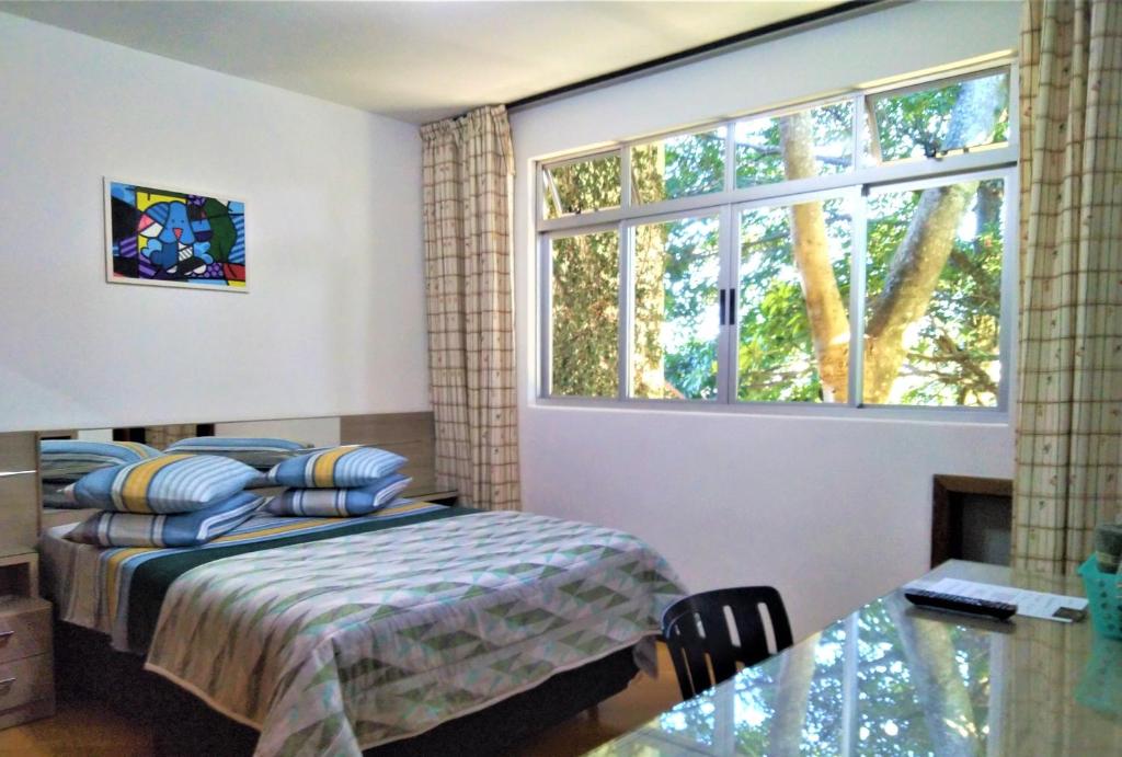 庫里奇巴的住宿－Pousada Casa Verde - Curitiba，一间卧室设有一张床和一个大窗户