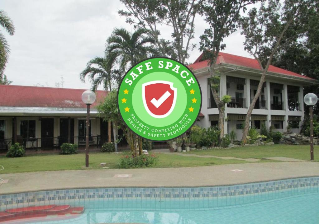 een resortbord voor een gebouw met een zwembad bij RedDoorz Plus @ Rio Grande de Laoag Resort Hotel Ilocos Norte in Laoag