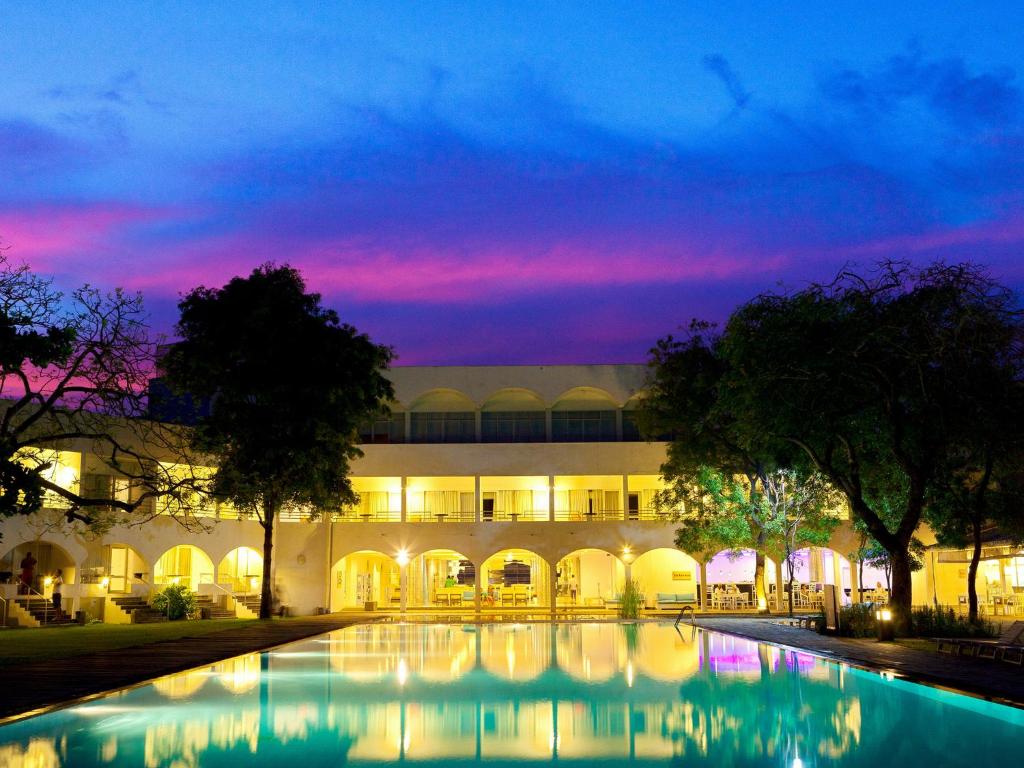 a building with a pool in front of it at night at Trinco Blu by Cinnamon in Trincomalee