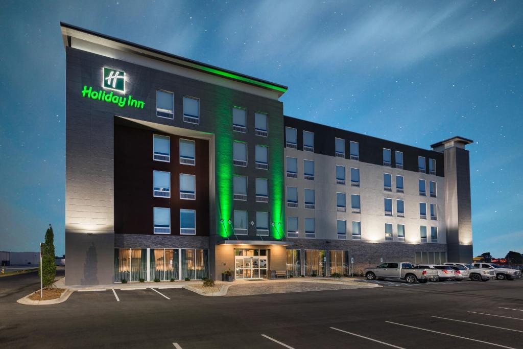 un hotel con luz verde en la parte delantera en Holiday Inn Greenville - Woodruff Road, an IHG Hotel, en Greenville