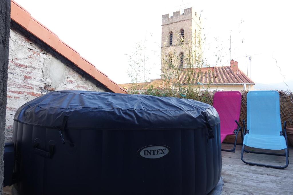two chairs and a trash can on a patio at Maison Small Luxury ( planxa,suite,solarium,jacuzzi,pas de vis à vis) in Argelès-sur-Mer