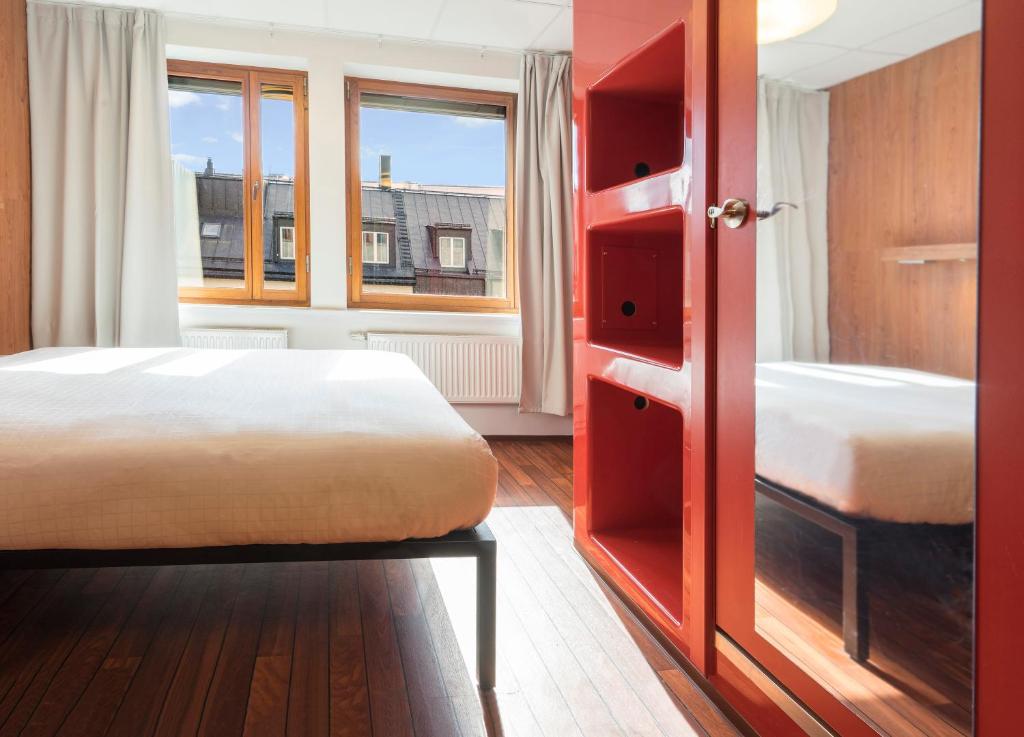 a bedroom with two beds and a large window at Generator Stockholm in Stockholm